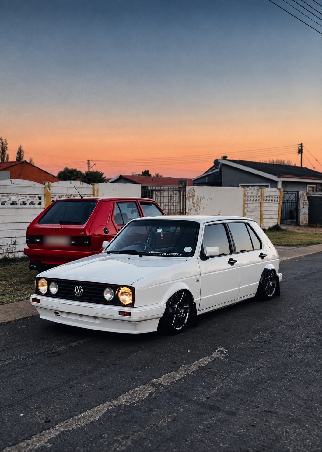 Bagged white and red VW Citi Golfs at sunset